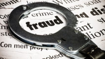 Handcuffs over newspaper with the word fraud
